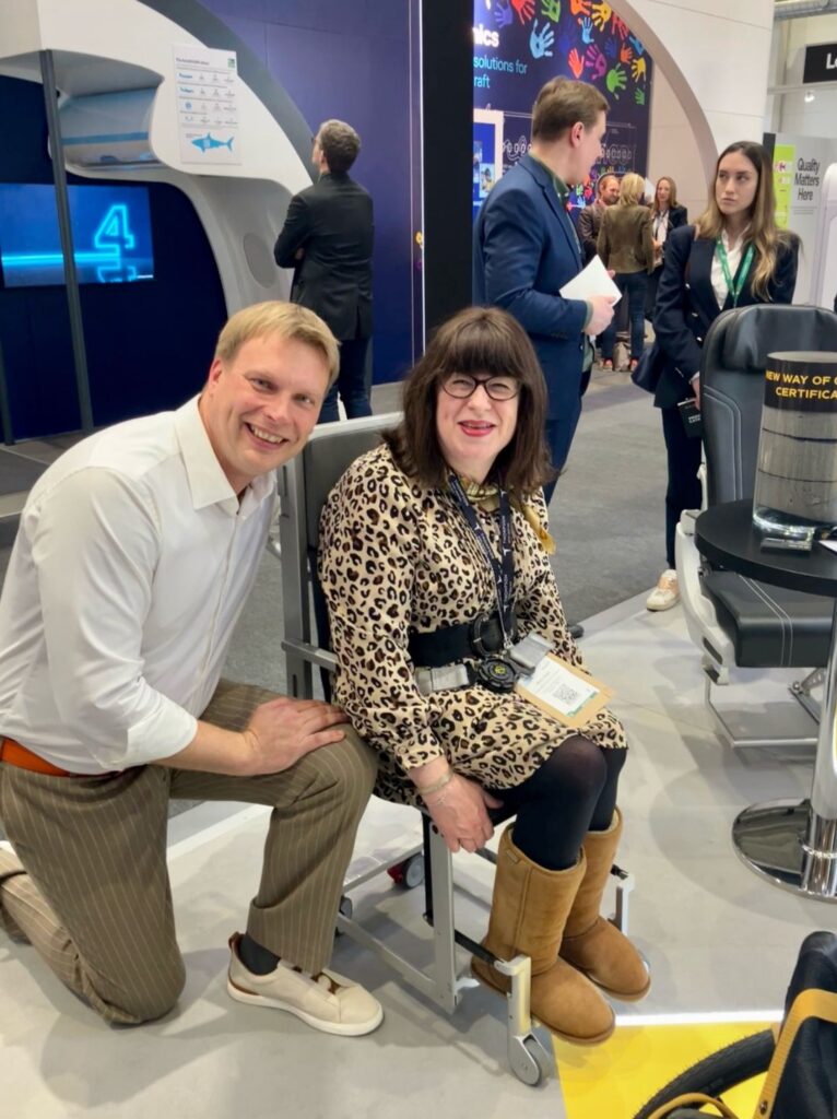 Mary Doyle in the J&C Aero aisle chair at AIX 2025
